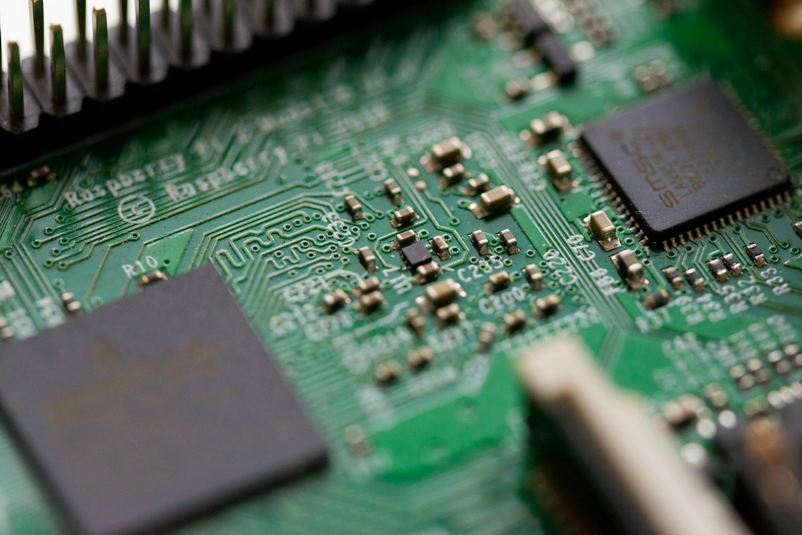 Hand working over a green circuit board